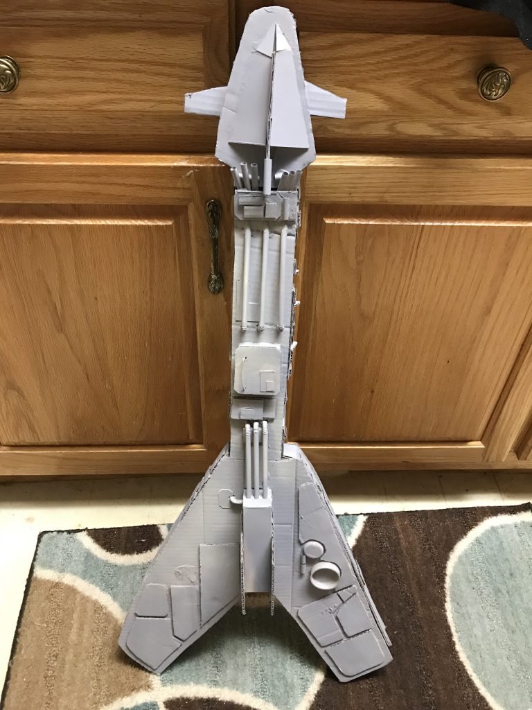 Cardboard model of a spaceship shaped like a flying-V guitar.