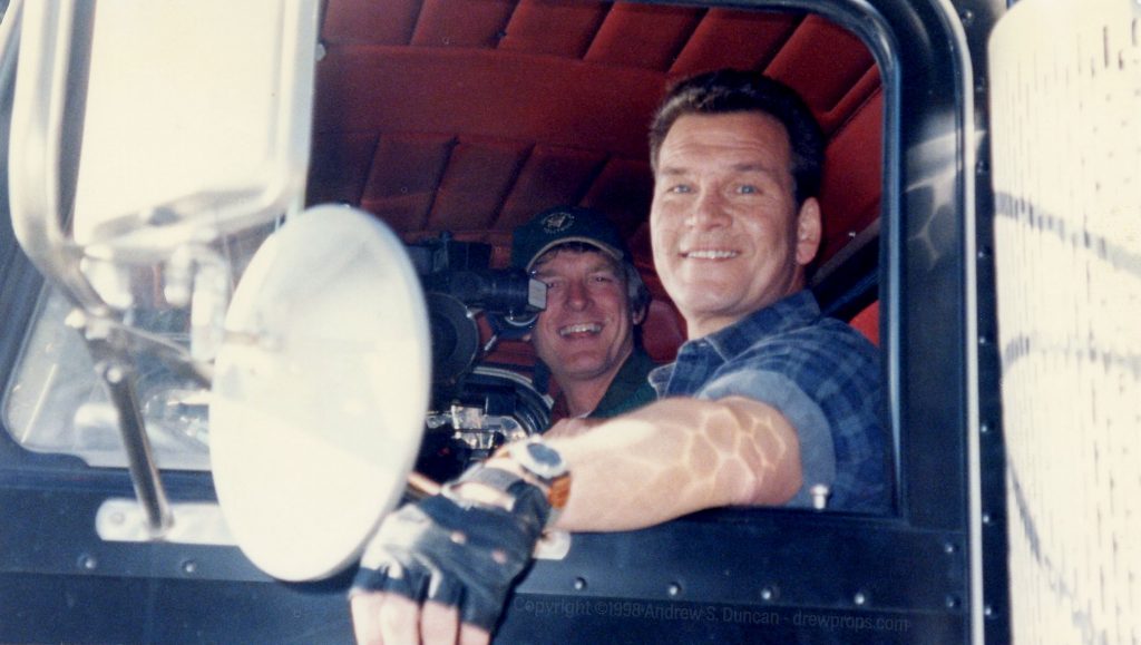 Camera operator Tom Weston and actor Patrick Swayze in the cab of the  hero truck of Black Dog. A stunt man drove the truck from a rig on the roof of the cab.